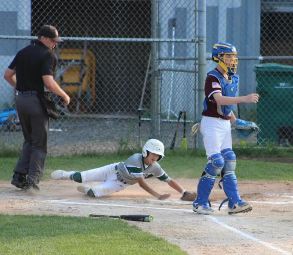 Dover's Trey Longuil slides safely into home plate during Tuesday's 2-1 win over Hudson in the Cal Ripken 12-year-old state tournament in Londonderry.