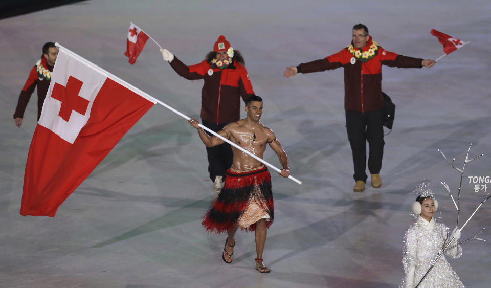 <p>Pita Taufatofua carries the flag of Tonga during the opening ceremony of the 2018 Winter Olympics in Pyeongchang, South Korea, Friday, Feb. 9, 2018. (AP Photo/Michael Sohn) </p>