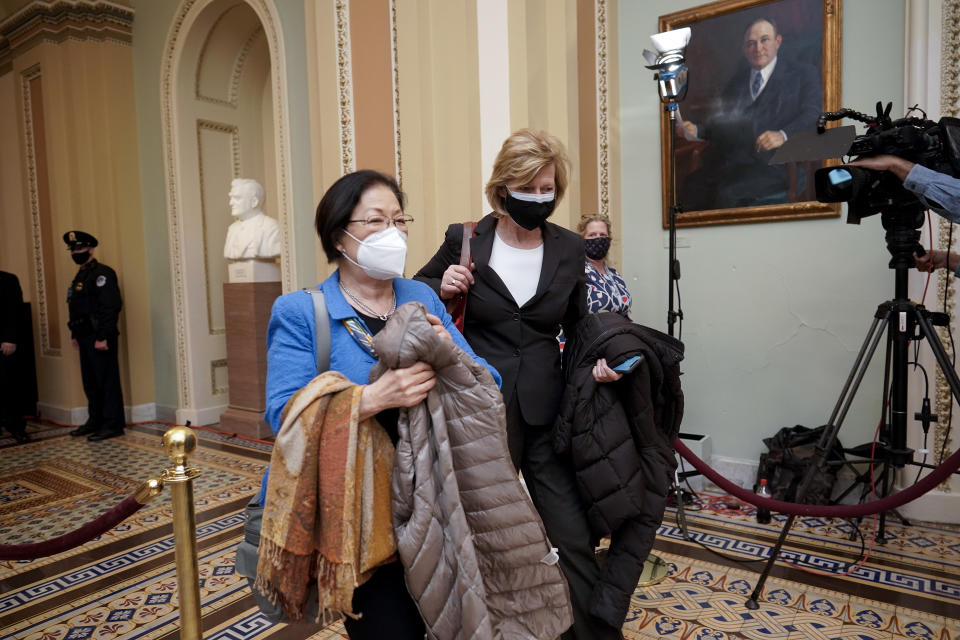 Sen. Mazie Hirono, D-Hawaii, left, and Sen. Tammy Baldwin, D-Wis., leave the Senate chamber as the impeachment trial of former President Donald Trump adjourns until Saturday, in Washington, Friday, Feb. 12, 2021. (AP Photo/J. Scott Applewhite)