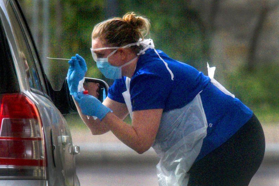 A nurse at a drive-through COVID-19 testing station in England.