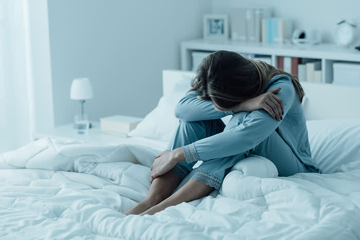 mujer sin poder dormir en la cama