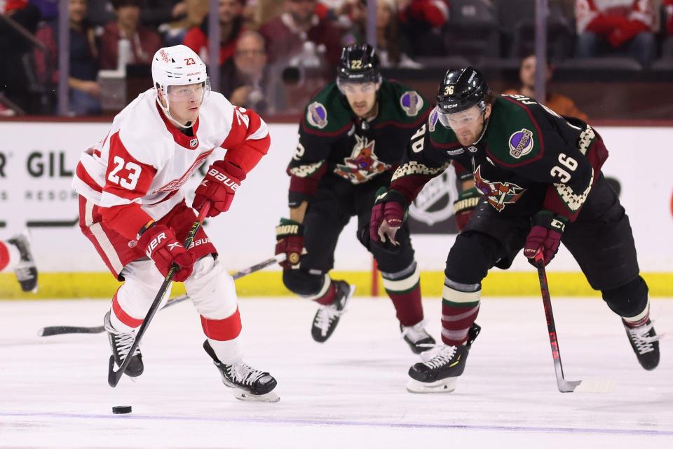 Red Wings forward Lucas Raymond skates with the puck ahead of the Coyotes' Christian Fischer during the first period on Tuesday, Jan. 17, 2023, in Tempe, Arizona.