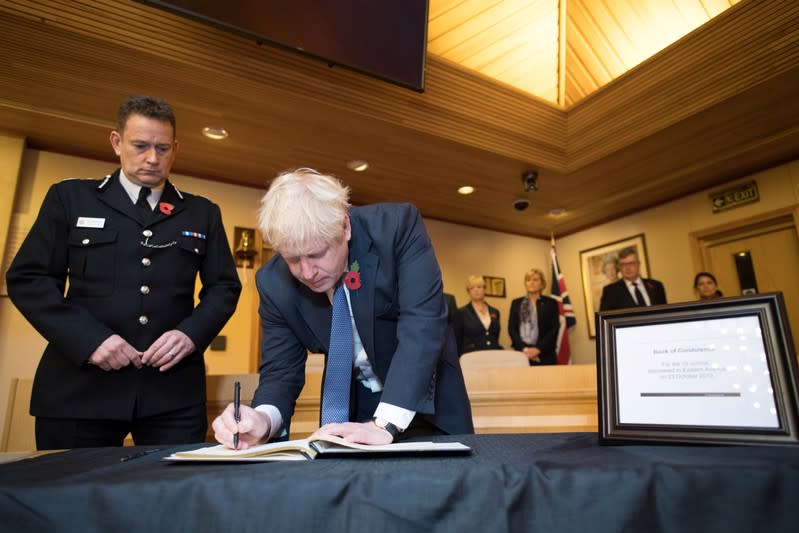 Britain's Prime Minister Boris Johnson signs a book of condolence during a visit to Thurrock Council Offices in Grays