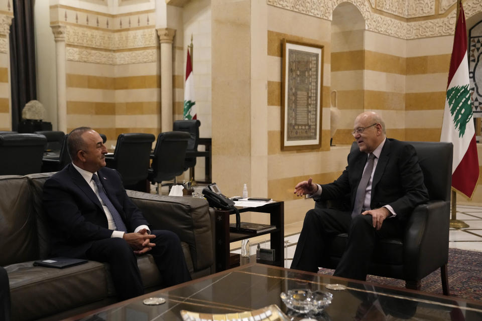 Turkey's Foreign Minister Mevlut Cavusoglu, left, meets with Lebanese Prime Minister Najib Mikati, at the government house in Beirut, Lebanon, Tuesday, Nov. 16, 2021. (AP Photo/Hassan Ammar)