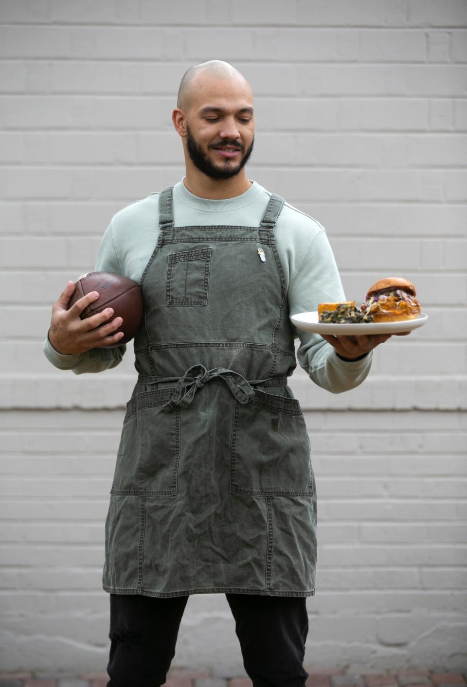 Former college football player Lawrence "L.T." Smith is seen with his pulled pork sandwich with Carolina Gold sauce, collared greens and baked mac and cheese at his home in Phoenix on January 26, 2021.