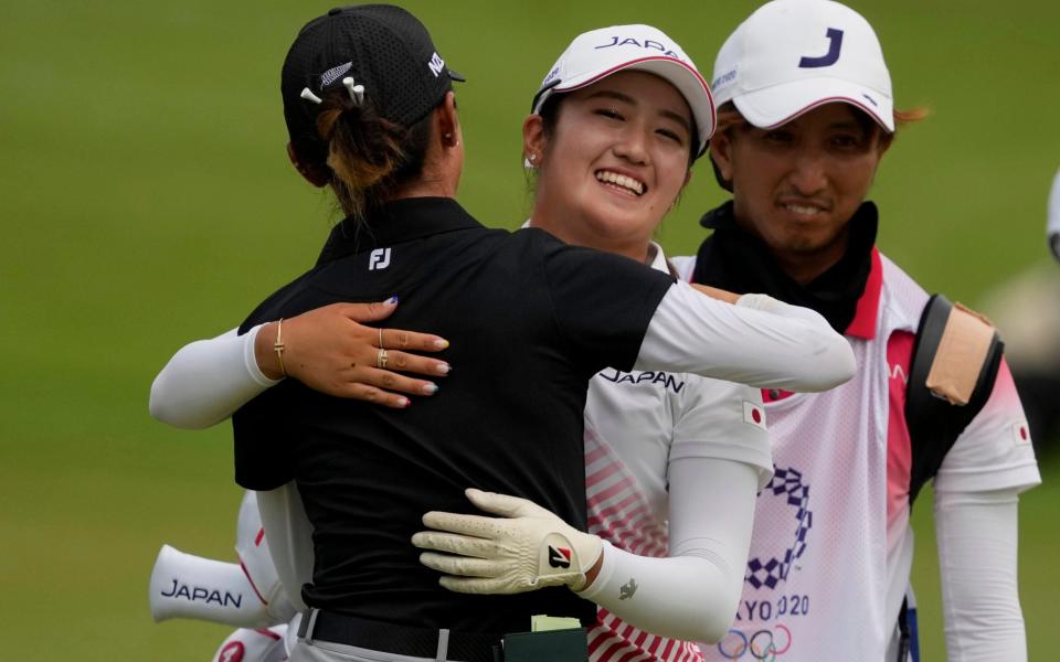 Mone Inami, of Japan, center, is congratulated by Lydia Ko, of New Zealand, after winning the silver medal. - AP Photo/Andy Wong