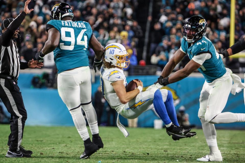 The Jaguars' Travon Walker (44) was penalized for roughing the passer after hitting the Chargers' Justin Herbert.