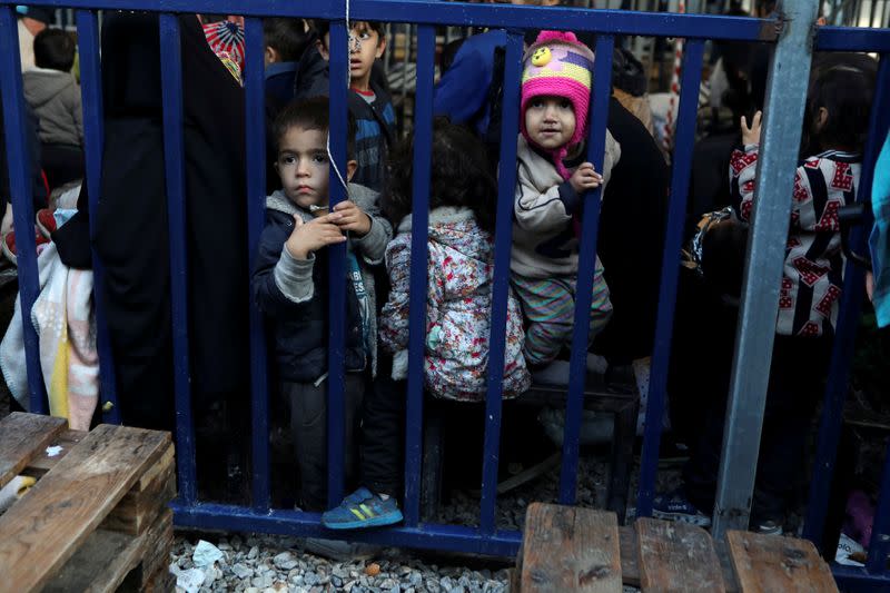 FILE PHOTO: Children stand next to a metal barrier as newly-arrived refugees and migrants wait to be registered at the Moria camp, on the island of Lesbos