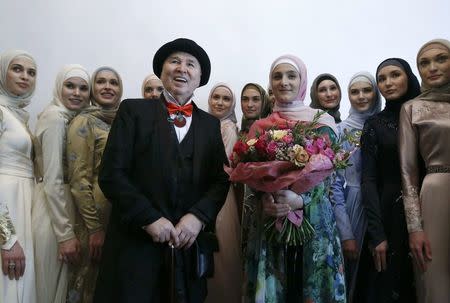 Designer Slava Zaitsev (front, L), Aishat Kadyrova (front, R), head of the Firdaws fashion house and daughter of the Chechen Republic leader Ramzan Kadyrov, and models pose for a picture during the Mercedes-Benz Fashion Week Russia in Moscow, Russia, March 17, 2017. REUTERS/Sergei Karpukhin