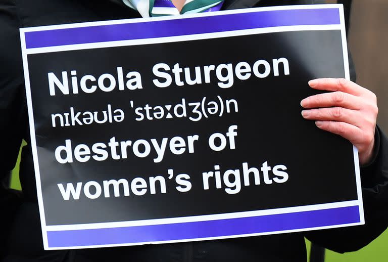 Manifestantes sostienen pancartas durante una protesta frente a Bute House, mientras la primera ministra de Escocia y líder del Partido Nacional Escocés (SNP), Nicola Sturgeon, anuncia su dimisión, en Edimburgo, el 15 de febrero de 2023. 