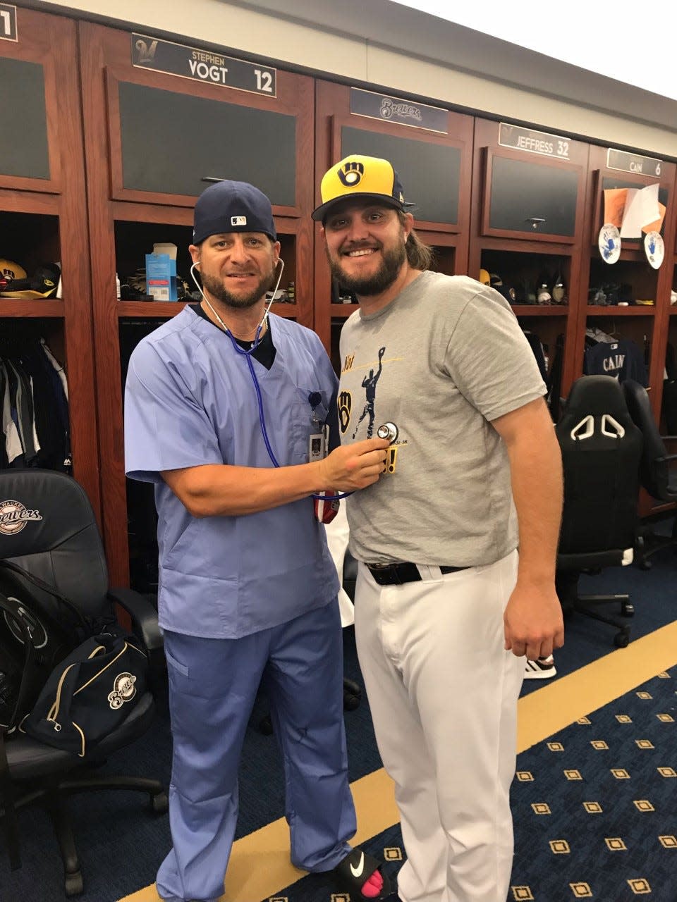Stephen Vogt (left) and Wade Miley pose on Aug. 21, 2018, the day after Vogt performed the Heimlich Maneuver on Miley in the Brewers clubhouse. Miley bought Vogt the doctor's scrubs and stethoscope as a lighthearted thank-you.