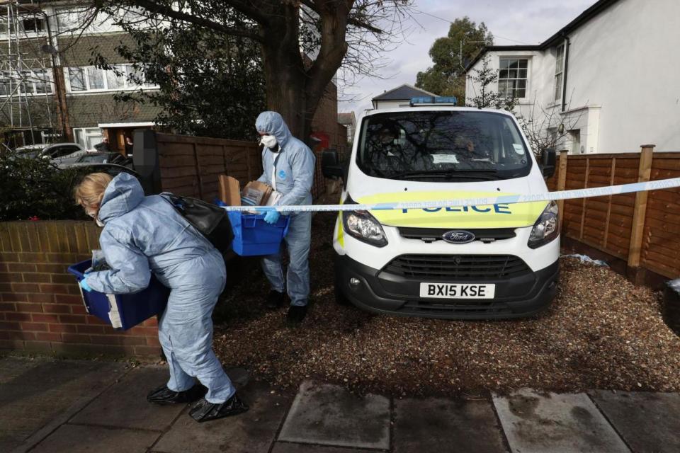 Murder probe: Forensic officers leave the property in South Road, Twickenham, where a woman was stabbed to death (PA)