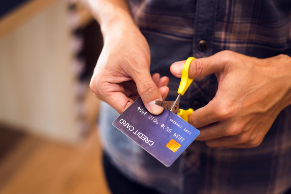 Hands cutting a credit card with scissors,copy space,vintage tone.