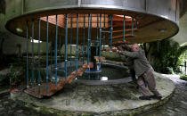 Bohumil Lhota, a 73-year-old builder, turns the house he built in Velke Hamry, near the town of Jablonec nad Nisou, 100km (62 miles) north-east from Prague, August 7, 2012. Lhota conceptualized the idea to create the unique house and started to build it in 1981, building it close to nature to benefit from the cooler ground temperature. Lhota's house, which is built in 2002, is able to move up and down and rotate on its sides, which allows him to adjust to his preferred window view. REUTERS/Petr Josek (CZECH REPUBLIC - Tags: BUSINESS CONSTRUCTION SOCIETY SCIENCE TECHNOLOGY) - RTR36EBU