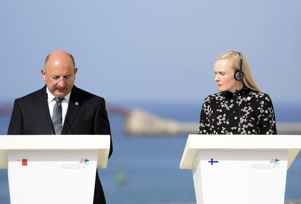 Maltese Interior Minister Michael Farrugia, left, speaks as Finnish Interior Minister Maria Ohisalo listens with headphones during a joint press conference at the end of an informal meeting of EU interior ministers, at Fort St. Angelo, in Birgu, Malta, Monday, Sept. 23, 2019. Five European Union nations have agreed to a temporary arrangement to take in migrants rescued from the central Mediterranean Sea. (AP Photo/Jonathan Borg)