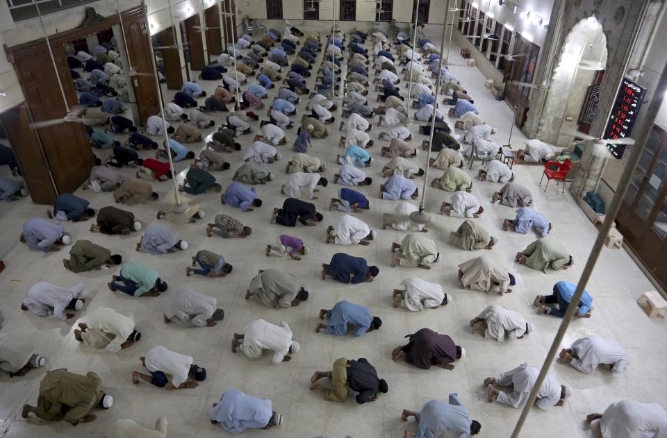 FILE- In this April 19, 2020 file photo, people attend evening prayers while maintaining a level of social distancing to help avoid the spread of the coronavirus, at a mosque in Karachi, Pakistan. The confirmed death toll from the coronavirus has gone over 50,000 in the Middle East as the pandemic continues. That's according to a count Thursday, Sept. 3, 2020, from The Associated Press, based on official numbers offered by health authorities across the region. (AP Photo/Fareed Khan, File)