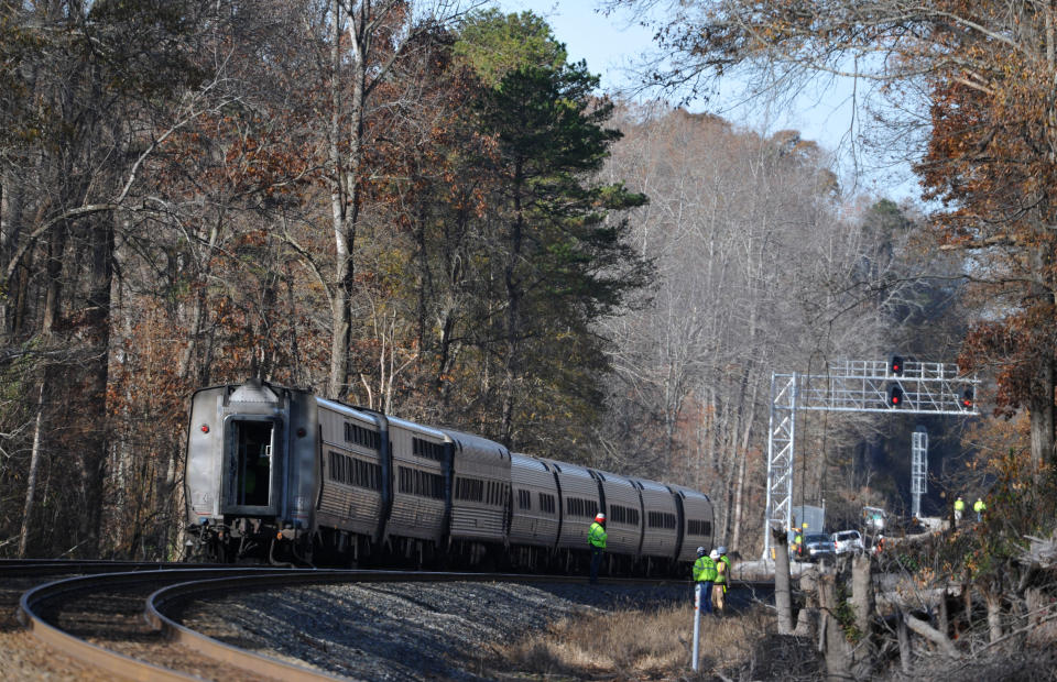 Workers are on the scene near the Amtrak Crescent train after it derailed, Monday, Nov. 25, 2013, in Spartanburg County, S.C. Several cars of the New York City-bound train with 218 people aboard went off the tracks early Monday as bags flew and jolted passengers clung to each other, authorities and passengers said. There were no serious injuries. (AP Photo/Rainier Ehrhardt)