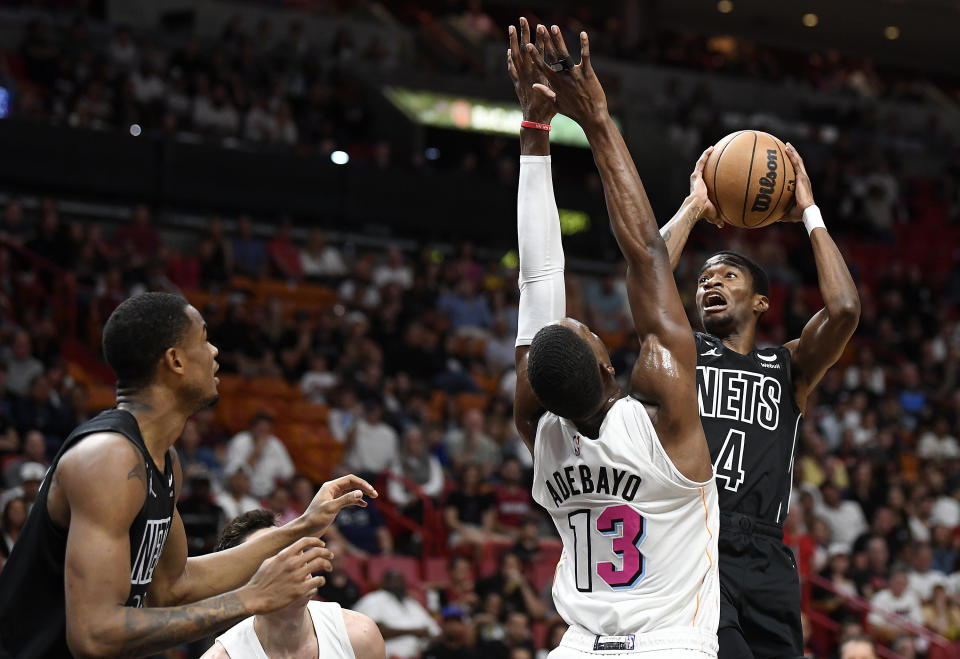 Brooklyn Nets guard Edmond Sumner (4) shoots over Miami Heat center Bam Adebayo (13) during the first half of an NBA basketball game, Saturday, March 25, 2023, in Miami, Fla. (AP Photo/Michael Laughlin)