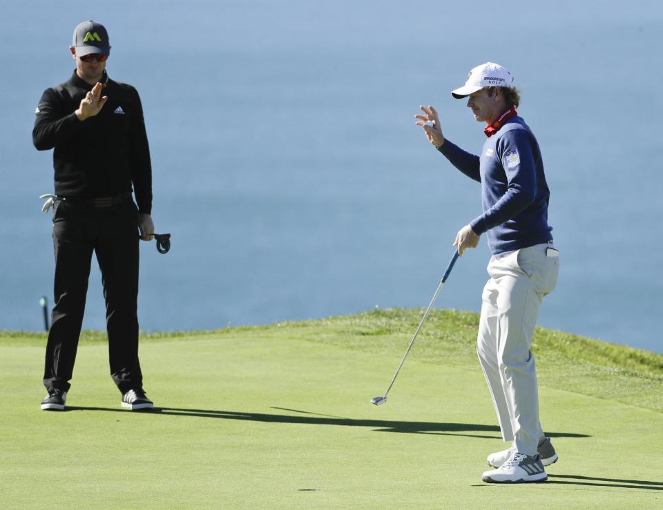 Brandt Snedeker, right, waves as Justin Rose lines up a putt on the second hole during the second round of the Farmers Insurance Open golf tournament on the South Course at Torrey Pines Golf Course on Friday, Jan. 27, 2017, in San Diego. (AP Photo/Chris Carlson)