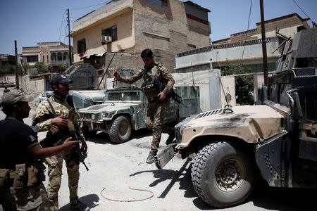 A member of Iraqi rapid response forces jumps of a vehicle during clashes with Islamic State fighters in western Mosul, Iraq May 27, 2017. REUTERS/Alkis Konstantinidis