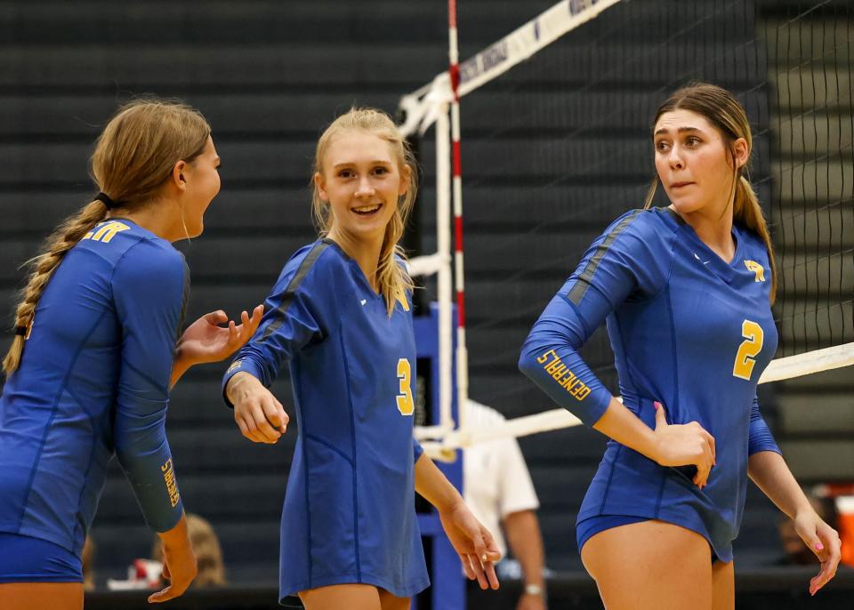 Wooster's Sara Snowbarger, Kylie Timko (3) and Josie Wright (2) share a few words before the start of the second set.