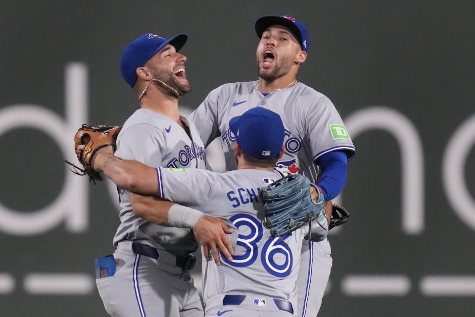 Toronto Blue Jays' George Springer, right, celebrates with Kevin Kiermaier, left, and Davis Schneider (36) after the Blue Jays defeated the Boston Red Sox 9-4 in a baseball game at Fenway Park, Tuesday, June 25, 2024, in Boston. (AP Photo/Charles Krupa)