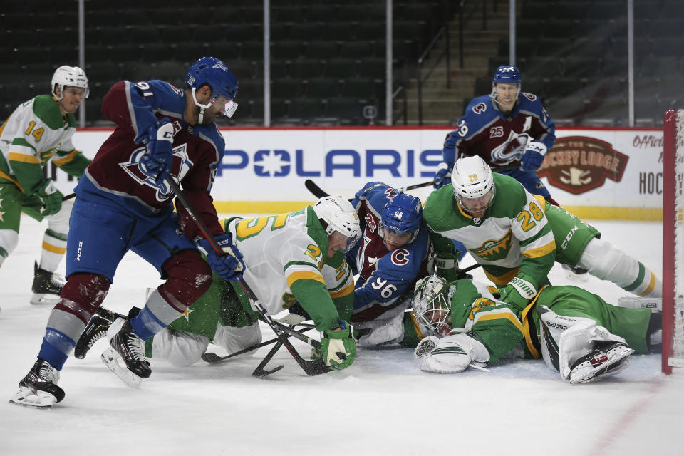 Minnesota Wild's goalie Cal Talbot (33) stops the puck in his glove under a pile of players in the second period of an NHL hockey game against the Colorado Avalanche, Sunday, Jan. 31, 2021, in St. Paul, Minn. (AP Photo/Stacy Bengs)