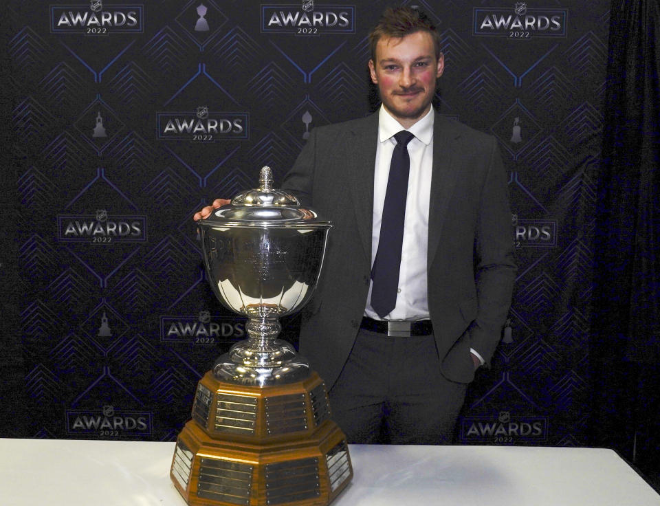 Colorado Avalanche's Cale Makar poses with the Norris Trophy after the NHL hockey awards Tuesday, June 21, 2022, in Tampa, Fla. The Norris Trophy is presented annually to the leagues' best defenseman. (AP Photo/John Bazemore)