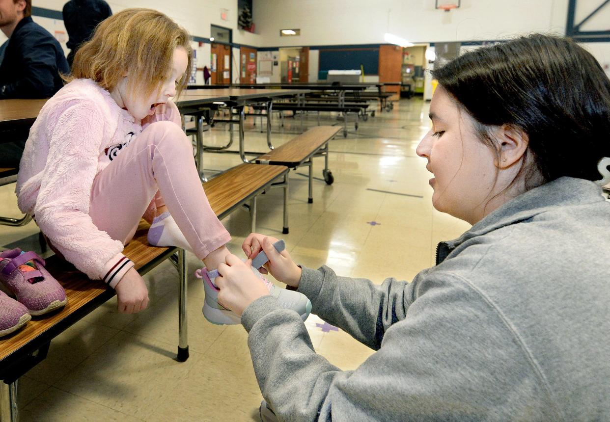 McClernand Elementary School first grader Paislee Paoni-Baker, 7, reacts as third-year SIU School of Medicine student Sophie Mounce puts her on a new pair of shoes at the school Tuesday. Mounce was one of several SIU students and faculty participating in "Shoes That Fit," a national program that gives new shoes and socks to schoolchildren.