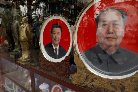 FILE PHOTO: Souvenir plates with images of Chinese late Chairman Mao Zedong (R) and Chinese President Xi Jinping are seen in Beijing, China, October 21, 2017. REUTERS/Tyrone Siu/File Photo?