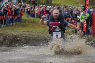 RNPS - REUTERS NEWS PICTURE SERVICE - PICTURES OF THE YEAR 2014 - ODDLY Eventual winners Jesse Wall carries Christina Arsenault through the water pit while competing in the North American Wife Carrying Championship at Sunday River ski resort in Newry, Maine in this October 11, 2014 file photo. REUTERS/Brian Snyder/Files (UNITED STATES - Tags: SPORT SOCIETY TPX IMAGES OF THE DAY)