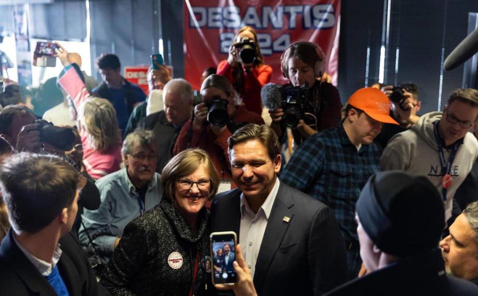 A supporter takes a photo with Florida Governor Ron DeSantis after he spoke during a rally at the Never Back Down super PAC headquarters on Saturday, Jan. 13, 2024, in West Des Moines, Iowa.