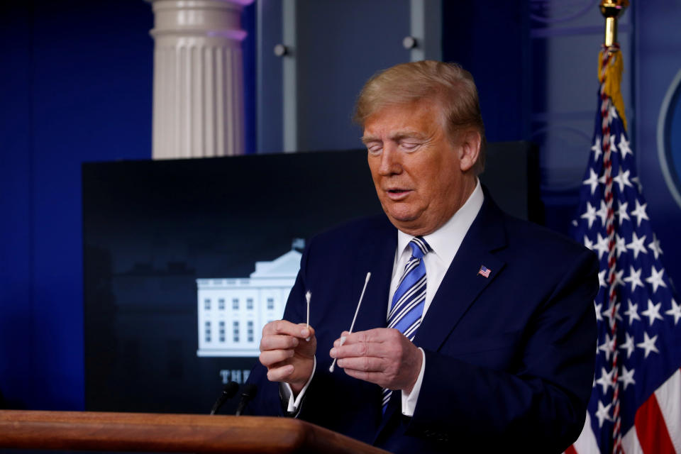 U.S. President Donald Trump compares a swab for coronavirus disease (COVID-19) testing with regular cotton swabs during the daily coronavirus task force briefing at the White House in Washington, U.S., April 19, 2020. REUTERS/Al Drago     TPX IMAGES OF THE DAY