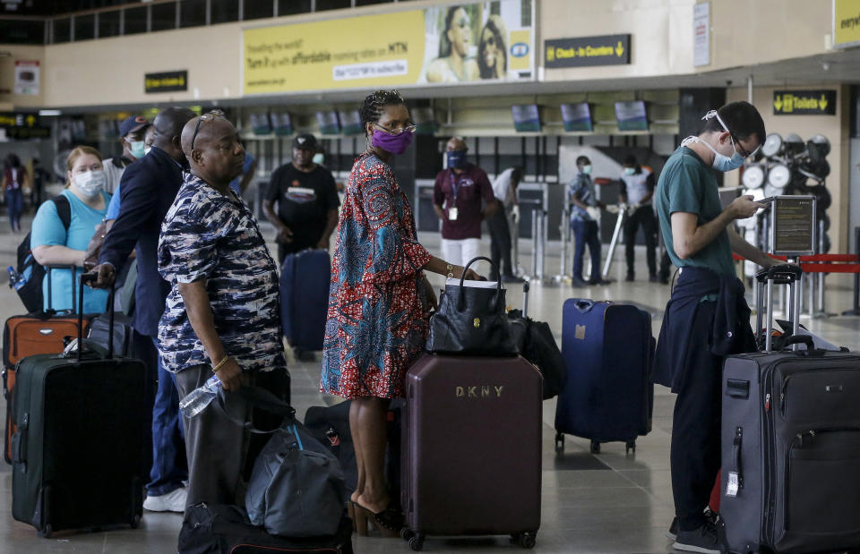 U.S. citizens queue to check in and be repatriated aboard an evacuation flight arranged by the U.S. embassy and chartered with Delta Air Lines, at the Murtala Mohammed International Airport in Lagos, Nigeria Tuesday, April 7, 2020. The new coronavirus causes mild or moderate symptoms for most people, but for some, especially older adults and people with existing health problems, it can cause more severe illness or death. (AP Photo/Sunday Alamba)