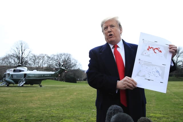 President Donald Trump shows a map of Syria and Iraq showing the presence of Islamic State in 2017 and 2019 as he speaks to reporters before leaving the White House in Washington