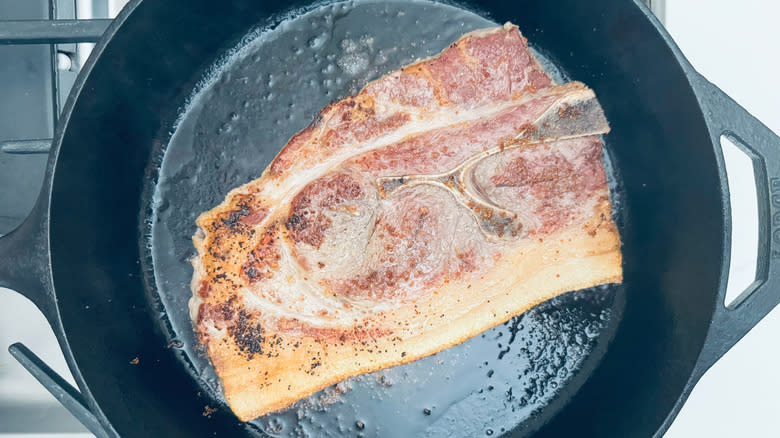 pork steak frying in pan