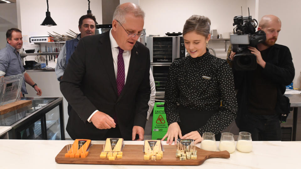 Scott Morrison tastes cheese while at a campaign even in Tasmania.