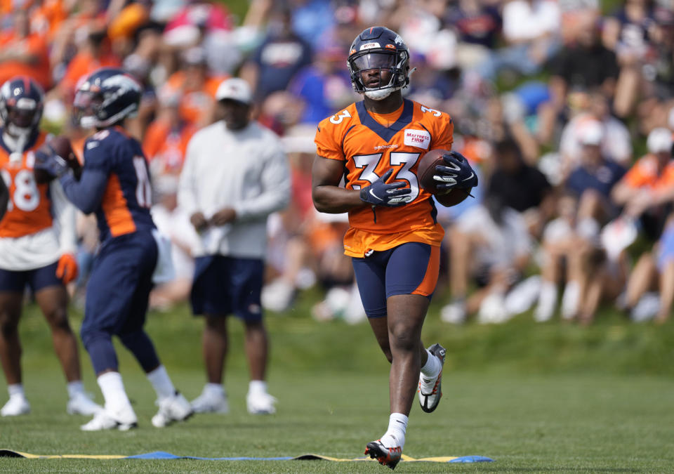 FILE -Denver Broncos running back Javonte Williams takes part in drills during the NFL football team's training camp Friday, July 29, 2022, in Centennial, Colo. Broncos running back Javonte Williams is using his downtime as he recovers from an injured right knee to feed his other passion: helping foster kids.(AP Photo/David Zalubowski, File)