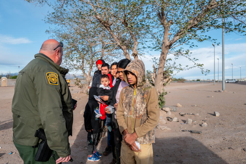 Un grupo de migrantes espera ser procesado después de cruzar el río Grande el 2 de abril de 2024 en El Paso, Texas. (Foto de Brandon Bell/Getty Images)