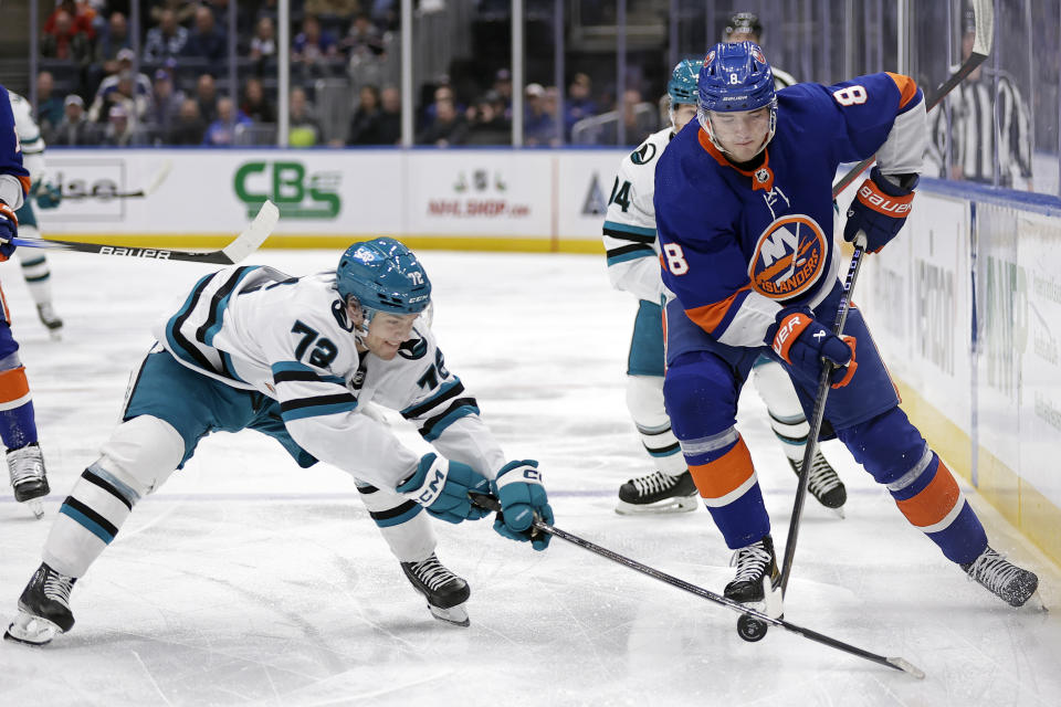 New York Islanders defenseman Noah Dobson (8) is defended by San Jose Sharks left wing William Eklund during the first period of an NHL hockey game Tuesday, Dec. 5, 2023, in Elmont, N.Y. (AP Photo/Adam Hunger)