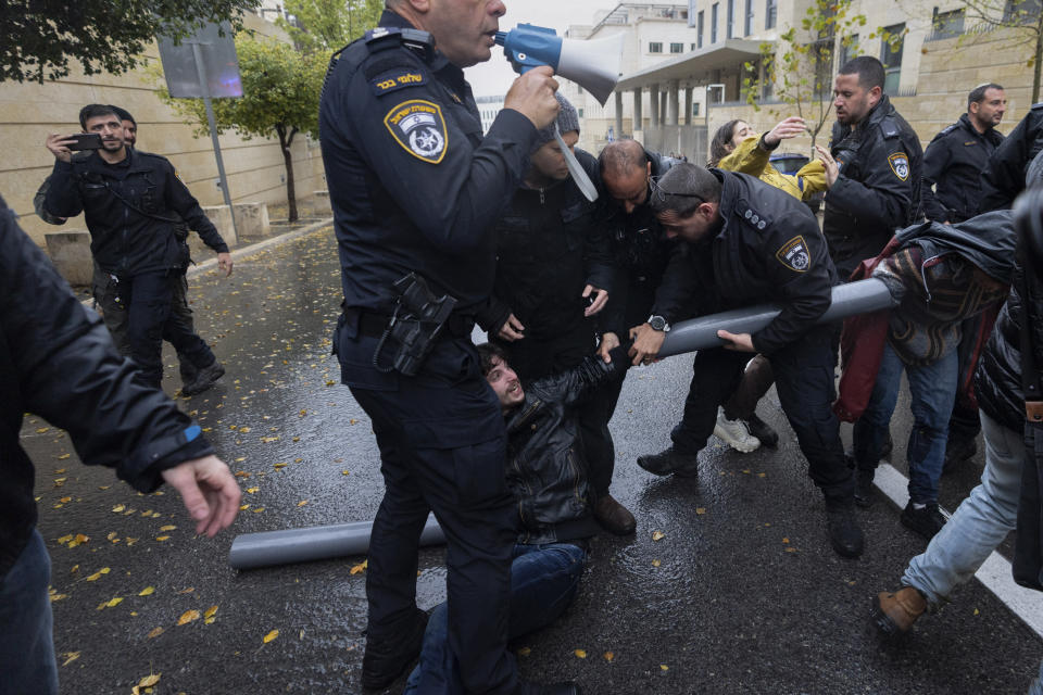 Police disperse demonstrators and activists as they block a road near the Ministry of Foreign Affairs and other government offices over plans by Prime Minister Benjamin Netanyahu's government to overhaul the judicial system, in Jerusalem, Tuesday, March 14, 2023. (AP Photo/Ohad Zwigenberg)