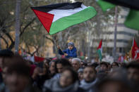 A boy waves a Palestinian flag as demonstrators march during a protest in support of Palestinians and calling for an immediate ceasefire in Gaza, in Barcelona, Spain, Saturday, Jan. 20, 2024, (AP Photo/Emilio Morenatti)
