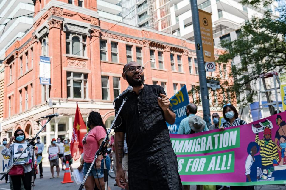 Syed Hussan, Executive Director of Migrant Workers Alliance speaks to demonstrators during an action in support of migrant worker rights in front of the Immigration and Refugee Board of Canada, in Toronto, in August 2020. 