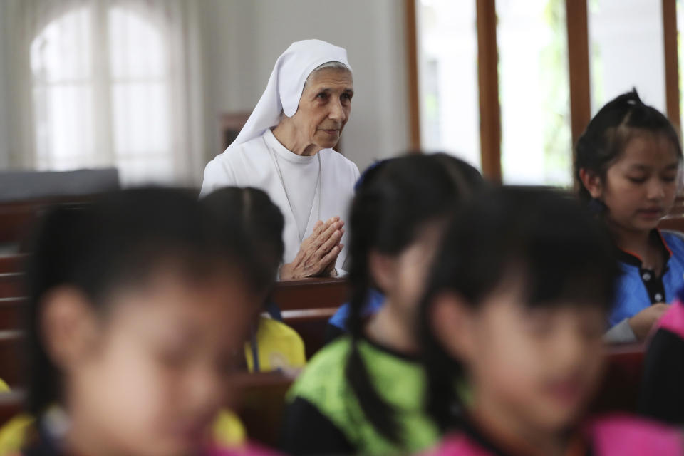 In this Aug. 27, 2019, photo, ST. Mary's School Vice Principal Sister Ana Rosa Sivori, rear, and students pray inside a church at the girls' school in Udon Thani, about 570 kilometers (355 miles) northeast of Bangkok, Thailand. Sister Ana Rosa Sivori, originally from Buenos Aires in Argentina, shares a great-grandfather with Jorge Mario Bergoglio, who, six years ago, became Pope Francis. So, she and the pontiff are second cousins. (AP Photo/Sakchai Lalit)