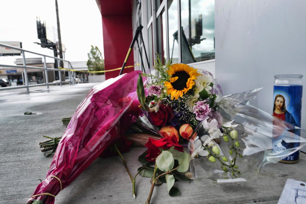 A votive candle and flowers are left for the teen who was fatally shot at a department store in North Hollywood section last week  (AP)