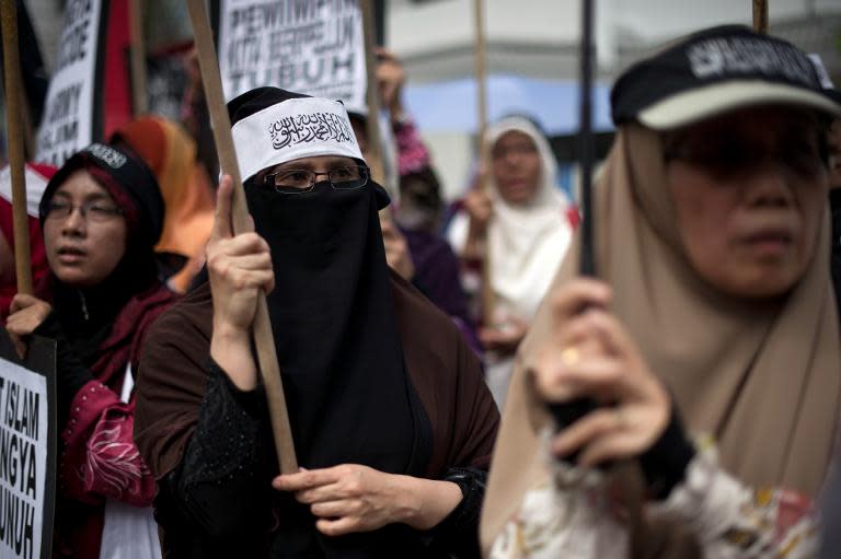 Malaysian Muslim activists carry flags and banners during a peaceful protest against the persecution of Rohingya Muslims in Myanmar, outside the Myanmar embassy in Kuala Lumpur, on February 14, 2014