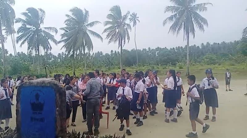 School students and staff gather in an open area after a magnitude 6.4 earthquake struck near Mentawai Islands, in South Nias