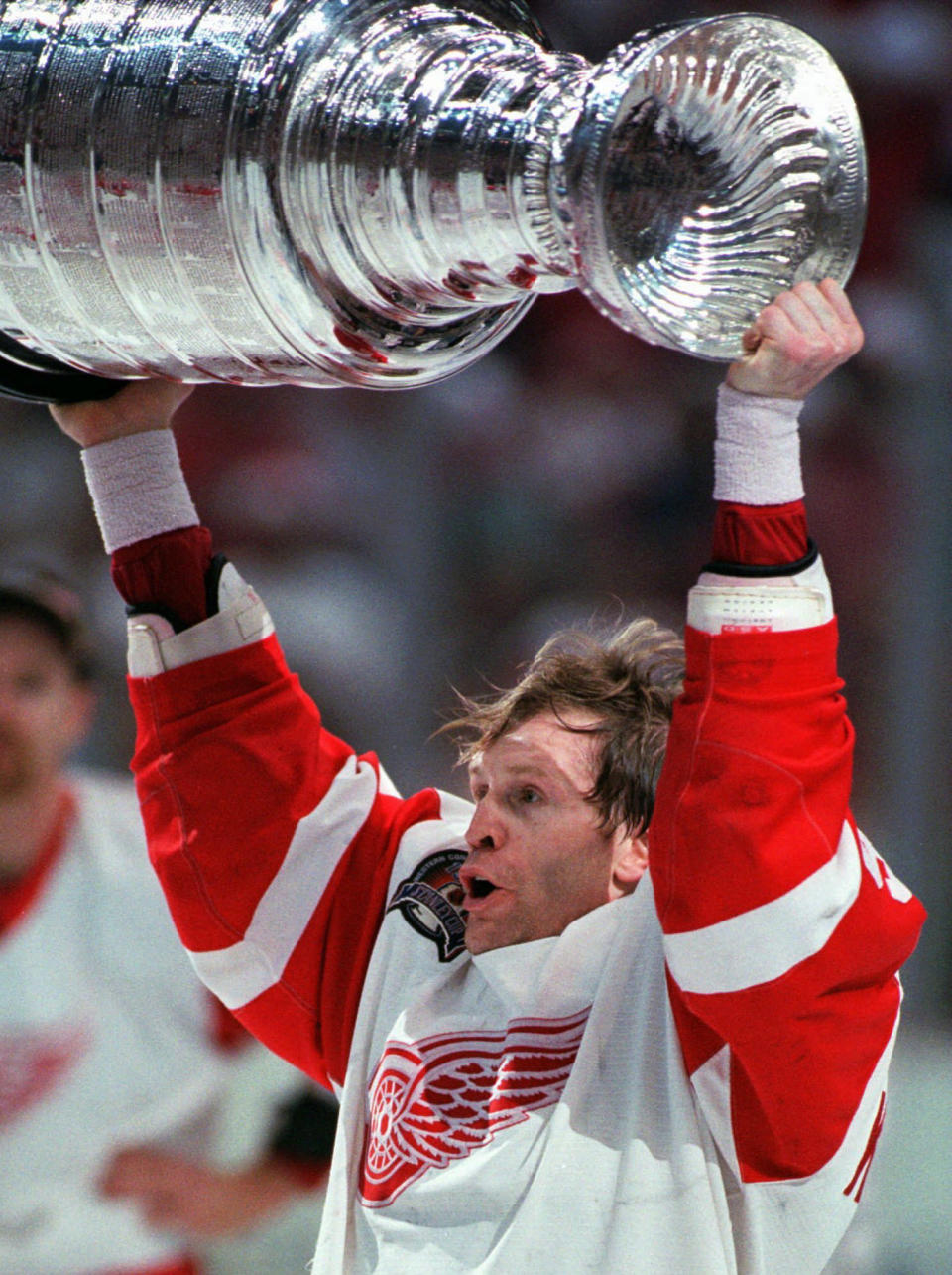 FILE- Detroit Red Wings hockey team defenseman Vladimir Konstantinov raises the Stanley Cup in celebration after Detroit swept the NHL hockey Stanley Cup finals over the Philadelphia Flyers on June 7, 1997, in Detroit, six days before he was almost killed in a limousine crash. Konstantinov is in danger of losing the 24/7 care he has had for two-plus decades. The disabled former defenseman is a casualty of changes to Michigan's auto insurance law that curbed or cut what hospitals, residential care facilities and home providers can charge car insurers for care. (AP Photo/Tom Pidgeon, File)