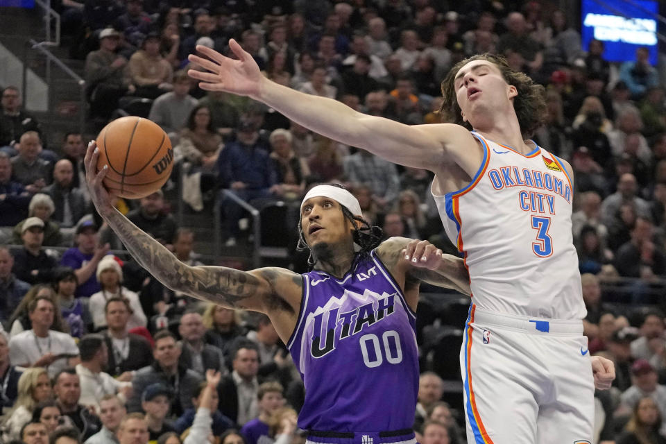 Utah Jazz guard Jordan Clarkson (00) pulls down a rebound as Oklahoma City Thunder guard Josh Giddey (3) defends during the first half of an NBA basketball game Tuesday, Feb. 6, 2024, in Salt Lake City. (AP Photo/Rick Bowmer)