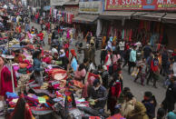 FILE - A police man, center, directs pedestrians towards a COVID-19 testing booth at a Sunday market in Jammu, India on Dec.5, 2021. In India, which has been getting back to normal after a devastating COVID-19 outbreak earlier this year, omicron is once again raising fears, with more than 700 cases reported in the country of nearly 1.4 billion people. (AP Photo/Channi Anand, File)